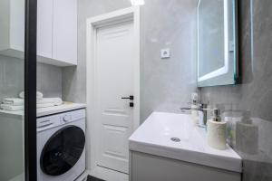 a white kitchen with a washing machine and a sink at Апартаменты на Гагарина in Almaty
