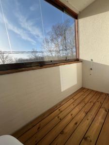 um quarto vazio com uma grande janela e pisos em madeira em Mugavustega korter pargi serval em Jõhvi