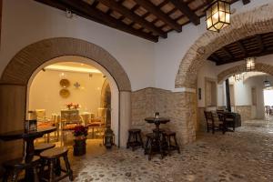 a restaurant with tables and chairs in a building at Hotel Tugasa Casa Palacio Medina Sidonia in Medina Sidonia