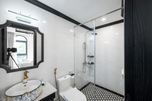 a bathroom with a toilet and a sink and a mirror at Le Palmier Phu Quoc Hotel in Phú Quốc +90 photos