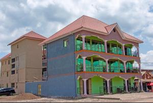 un gran edificio con zonas verdes y marrones en CAR-NET HOTEL en Kisoro