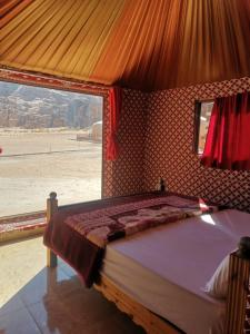 Schlafzimmer mit einem Bett und Blick auf die Wüste in der Unterkunft Salman Zwaidh Camp in Wadi Rum