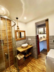 a bathroom with a sink and a mirror and a shower at Domek Babiogórski z JACUZZI in Zubrzyca Górna