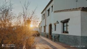 a building with the sun setting in the background at Mas del Tancat in Amposta