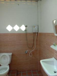 a bathroom with a shower and a toilet and a sink at Cha Bungalow in Ko Yao Noi