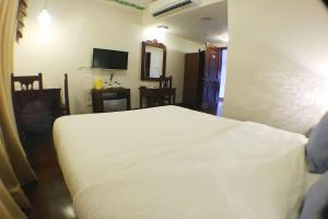 a bedroom with a white bed in a room at NSCC Hotel Vigan in Vigan