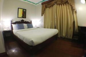 a bedroom with a large bed and a window at NSCC Hotel Vigan in Vigan