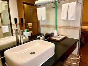 a bathroom with a white sink and a mirror at Paco Hotel Tuanyida Metro Guangzhou -Free ShuttleBus for Canton Fair in Guangzhou