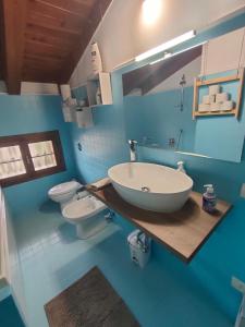 - une salle de bains bleue avec lavabo et 2 toilettes dans l'établissement la casetta di Giò, à Montebelluna