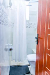 y baño con aseo y ducha. en SeaEsta suite 64 Nyali Mombasa, en Nyali