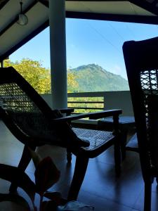 a porch with a hammock and a view of a mountain at Travels Nest Homestay in Gampola