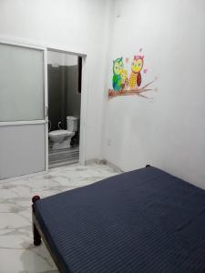 a white room with a bed and a bathroom at Travels Nest Homestay in Gampola