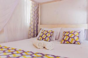 a bed with two towels and two pillows on it at SeaEsta suite 64 Nyali Mombasa in Nyali