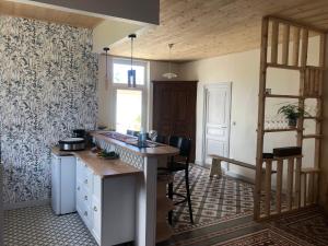 a kitchen with a counter and a table in a room at La Sirène in Grand-Village-Plage