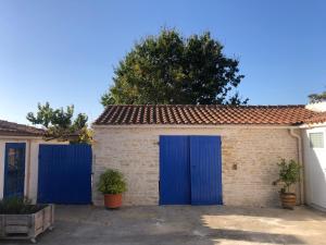 a garage with blue doors in a parking lot at La Sirène in Grand-Village-Plage