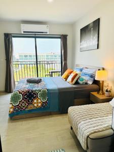 ein Schlafzimmer mit einem Bett und einem großen Fenster in der Unterkunft HuaHin La Casita condo Quiet, bright room with nice view Netflix vip #2 in Hua Hin