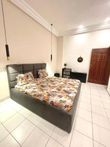 1 dormitorio con 1 cama grande con colcha. en Timba log-aupiais, en Cotonou