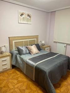 a bedroom with a bed and a wooden floor at Les Xanes de Candas in Gijón
