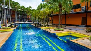 una piscina en un hotel con palmeras en Nongnooch Garden Pattaya Resort, en Ban Nong Chap Tao