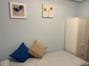 a bedroom with two blue pillows on a bed at Les Xanes de Candas in Gijón