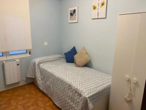a small bedroom with a bed in a room at Les Xanes de Candas in Gijón