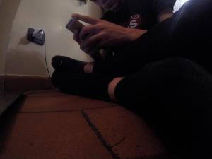 ソイアーノ・デル・ラーゴにあるIl Ghetto Farm Holidayの携帯電話を持つ床に座っている者