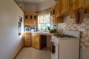 a kitchen with wooden cabinets and a white stove top oven at Eleven30 Luxury Apartment 2B in Negril