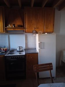a kitchen with wooden cabinets and a stove and a refrigerator at Stone cottage in Sígrion +31 photos