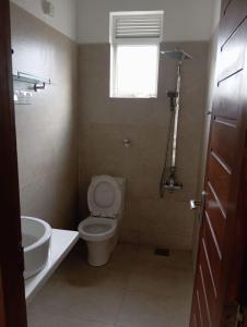 a bathroom with a toilet and a sink and a window at Kelaniya Heritage in Kelaniya