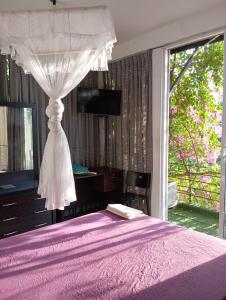1 dormitorio con cama morada y dosel en Kelaniya Heritage en Kelaniya
