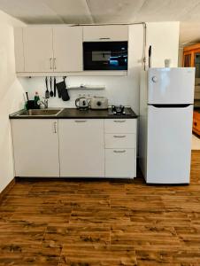 a kitchen with white cabinets and a white refrigerator at Haus mit fantastischem Meerblick in Mácher