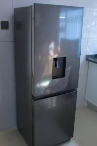 a stainless steel refrigerator in a kitchen at Gaborone 1 bed suburban bliss in Gaborone