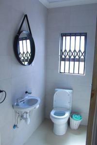 a white bathroom with a toilet and a sink at Gaborone 1 bed suburban bliss in Gaborone