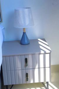 a blue lamp on a nightstand with a lamp on it at Gaborone 1 bed suburban bliss in Gaborone