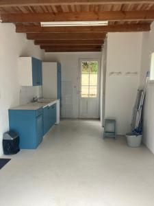 eine leere Küche mit blauen Schränken und einem Fenster in der Unterkunft Maison 100 m2 plein pied pour 6 personnes 300 m de la plage in Chaucre + 11 Fotos