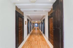 a hallway with wooden doors and a long hallway with wood floors at FabHotel Prime The Continental in Lucknow
