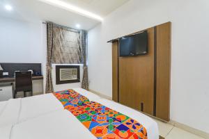 a bedroom with a bed and a flat screen tv at FabHotel Prime The Continental in Lucknow