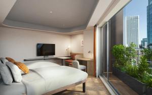 a bedroom with a white bed and a large window at Mitsui Garden Hotel Ginza Tsukiji in Tokyo