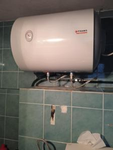 a water heater on the wall of a bathroom at Stone house cottage in Sígrion