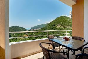 a table and chairs on a balcony with a view at Apartments Villa Relax in Petrovac na Moru