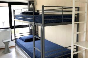 two bunk beds with blue sheets in a room at De Woning, Wijk de Brabander 109 in Cadzand