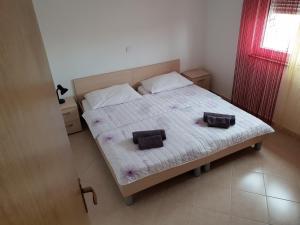 a bedroom with a bed with two pillows on it at Apartmani I+J Miletic in Vodice