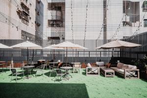 an outdoor patio with tables and chairs and umbrellas at Hub Hotel Kaohsiung Yawan Branch in Kaohsiung
