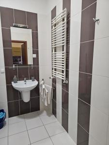 ein Bad mit einem Waschbecken und einem Spiegel in der Unterkunft Apart in Radomsko