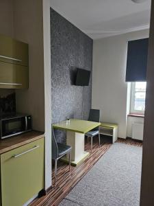 een kleine kamer met een tafel en 2 stoelen bij Apart in Radomsko