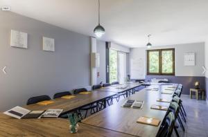 une grande salle de conférence avec une grande table et des chaises dans l'établissement Le gite de la tour, à Bressieux