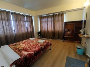 um quarto com uma cama com um cobertor vermelho em New Maya Residency em Darjeeling