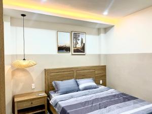 een slaapkamer met een bed en een hanglamp bij Cozy House in Ho Chi Minh-stad