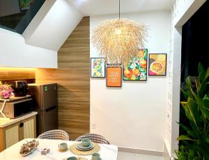 een keuken met een tafel en wat foto's aan de muur bij Cozy House in Ho Chi Minh-stad