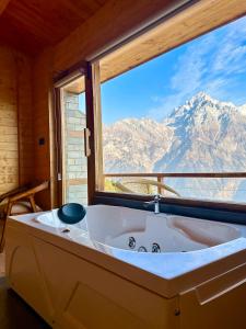 a bath tub in a room with a large window at FAYUL RETREAT - India Highest Glamp and EcoLuxury Stay in Kalpa